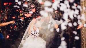 Sposi sorridenti escono dalla chiesa mentre gli invitati lanciano riso celebrando il loro matrimonio.