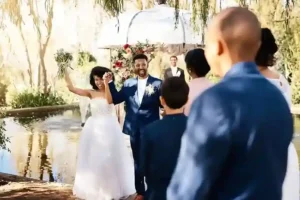 Coppia di sposi sorridente mentre esce dalla cerimonia, catturata in un wedding video che celebra l’emozione del loro giorno speciale